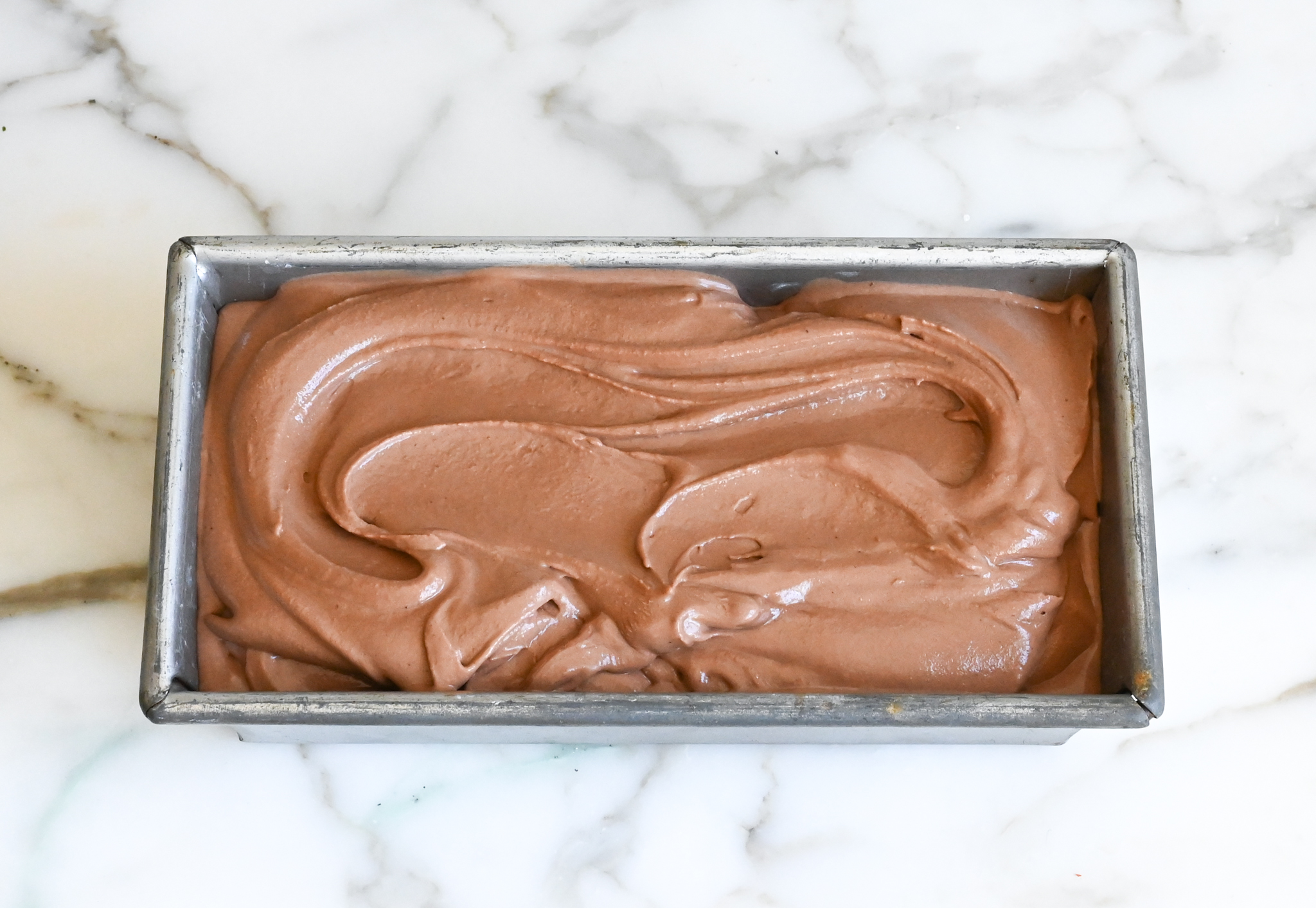 glace au chocolat dans un récipient prêt à congeler